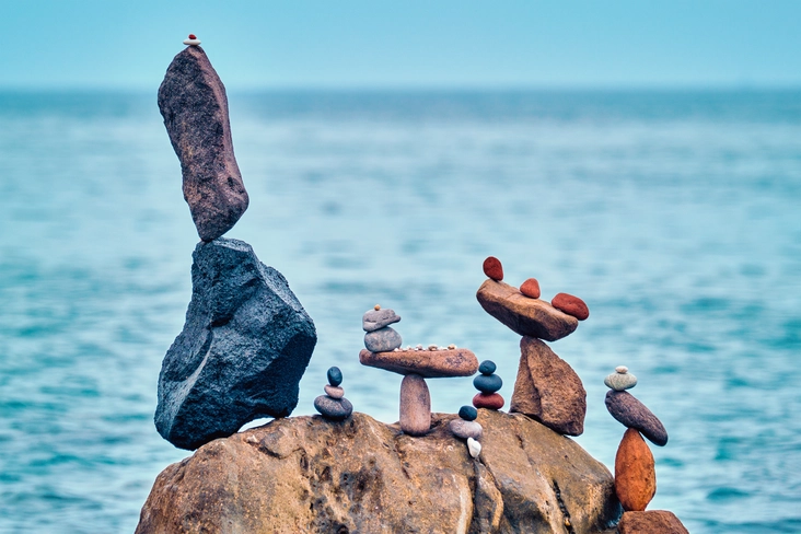 Artistic stone stacks balancing on a seaside rock, symbolizing harmony and tranquillity